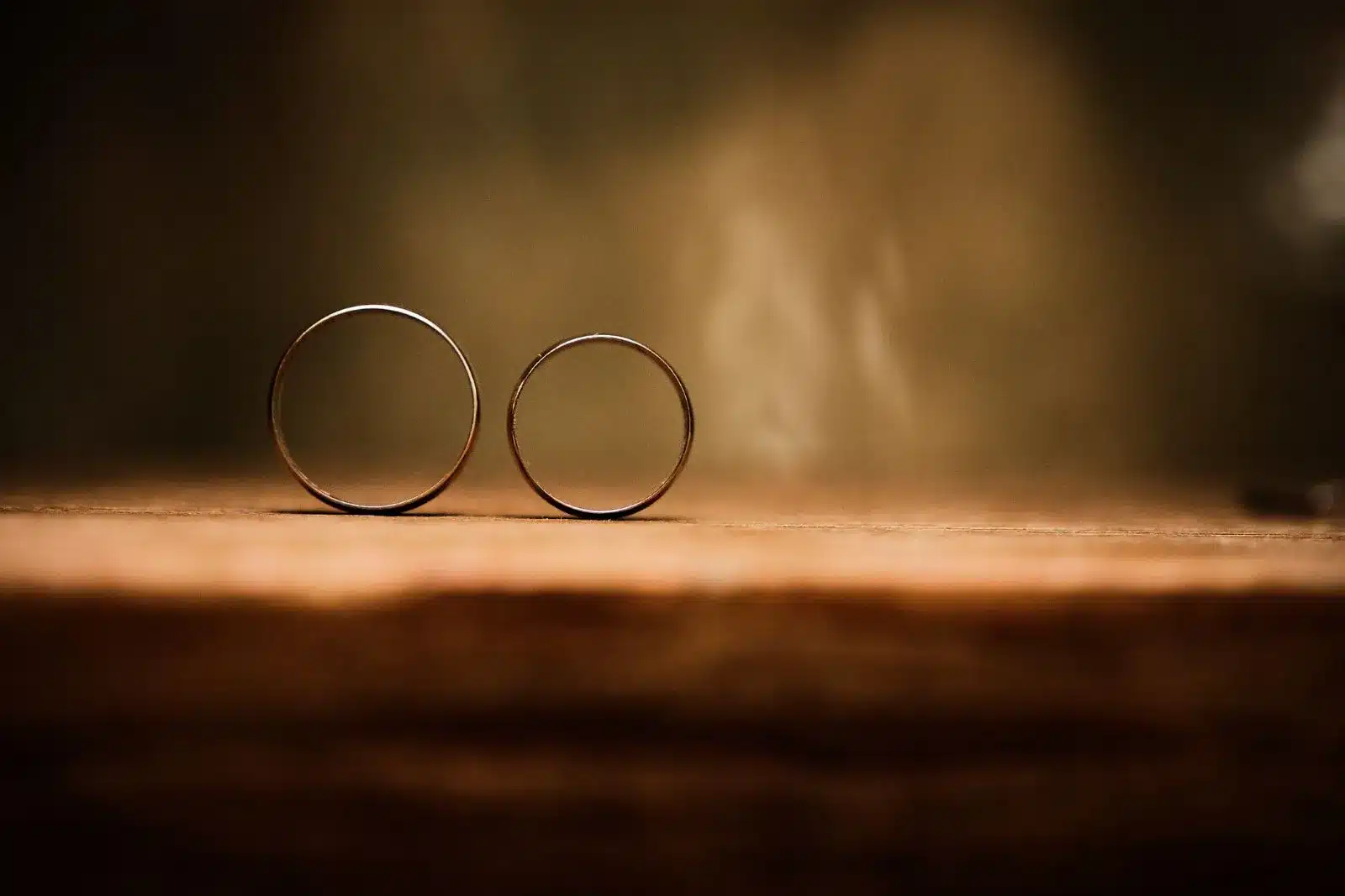 2 weddings rings standing upright on a desk.
