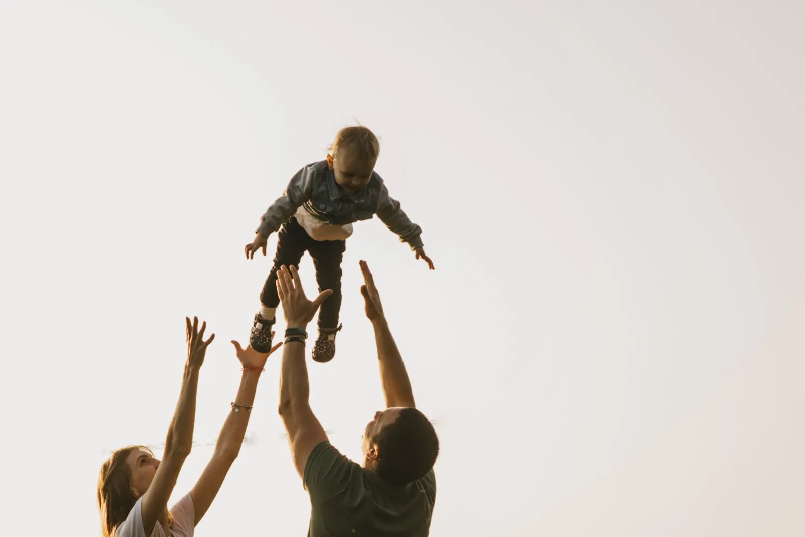 Parents throwing their kids into the air