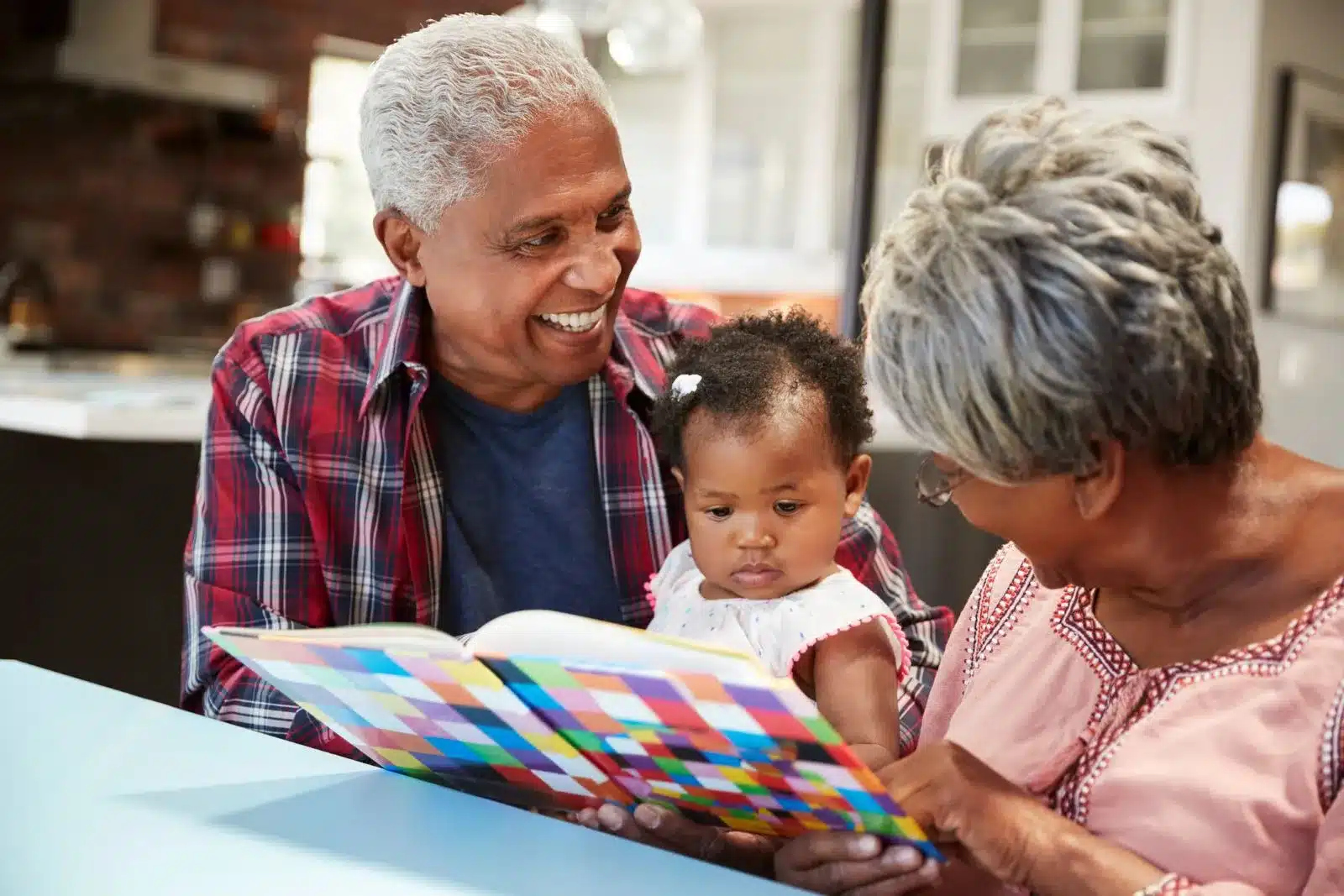 Grandparents reading a book to their granddaughter